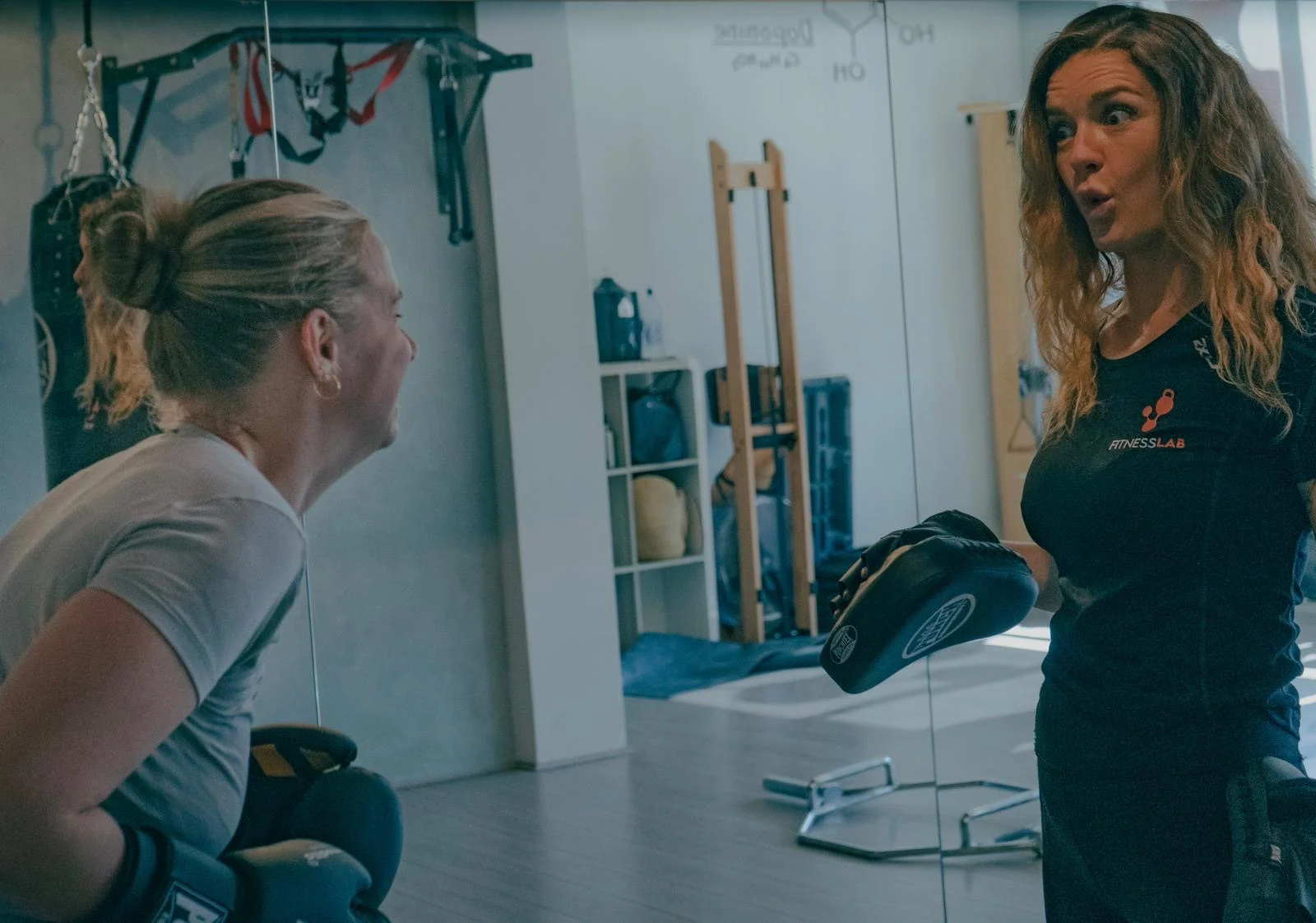 A coach faces a client during a conversation in a FitnessLab studio.